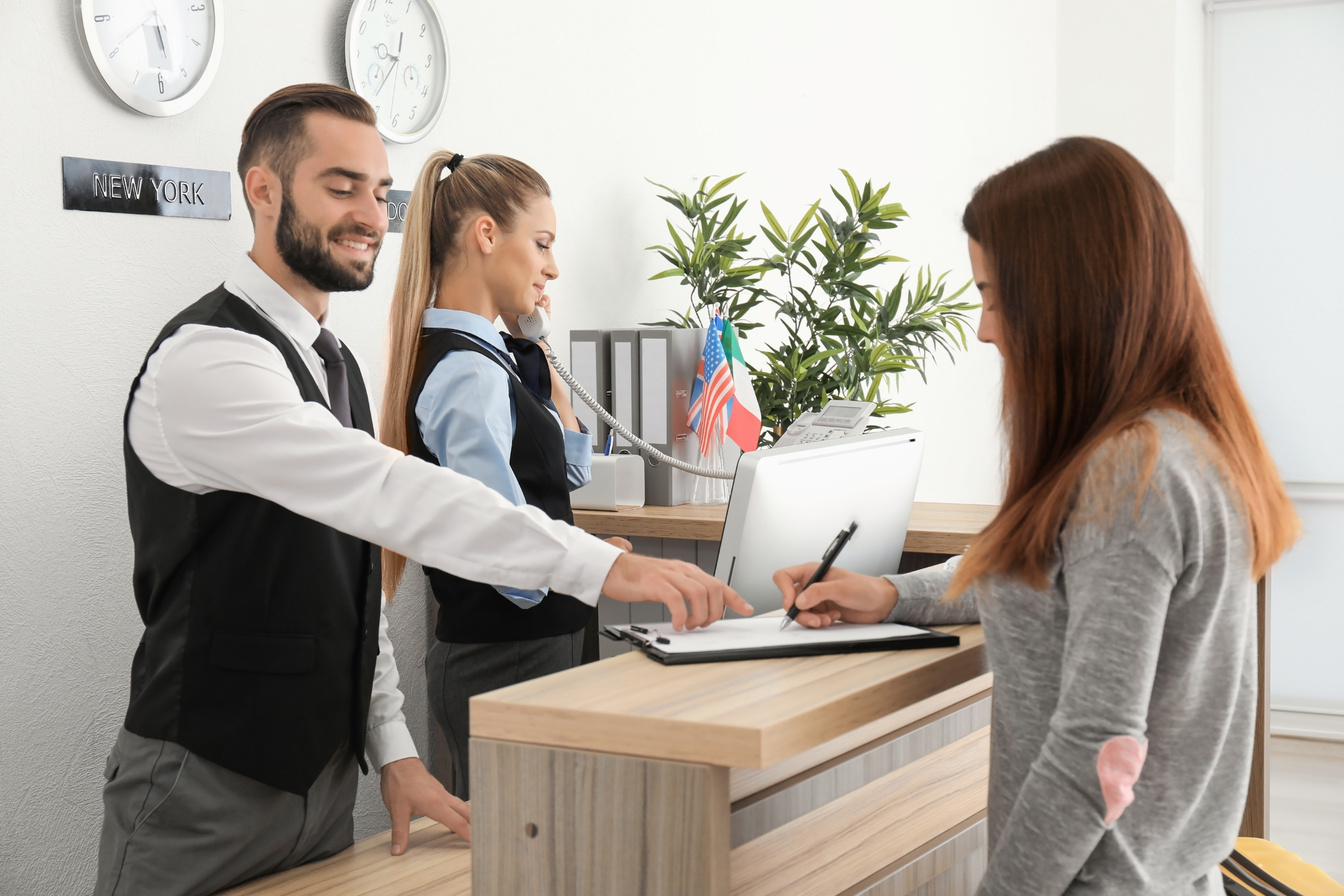 Young Woman Near Reception Desk in Hotel